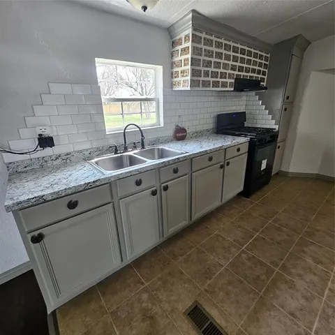 a kitchen with a sink stove and cabinets