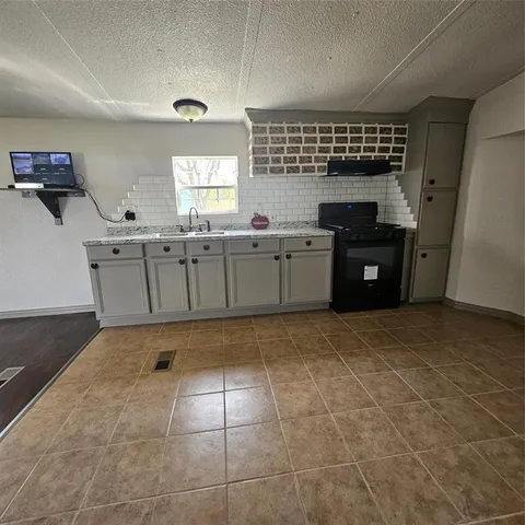 a kitchen with a sink window and cabinets
