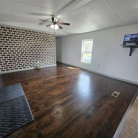 an empty room with wooden floor and cabinet