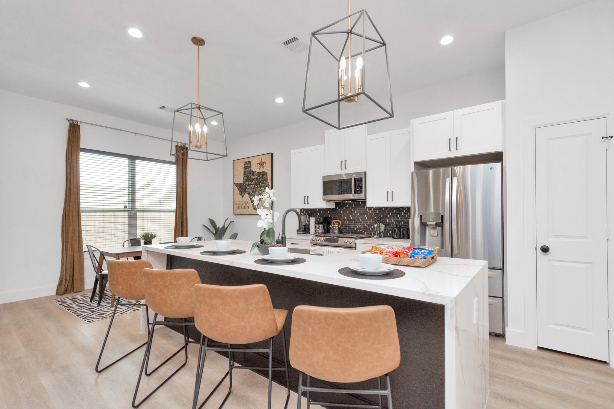 5308 Denmark Street Houston, TX 77028 - Photo 12 of 36 a open dining room with stainless steel appliances kitchen island granite countertop a table chairs and a chandelier