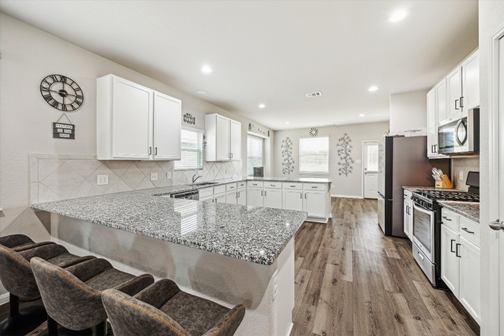 a kitchen with stainless steel appliances granite countertop a sink refrigerator and microwave
