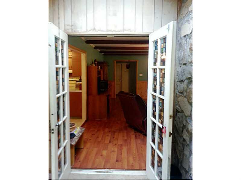 13 Hemlock Road Laughlintown, PA 15655 - Photo 10 of 22 Sunroom. French doors take you from the sun room to the living room. Note the stone wall to the right.