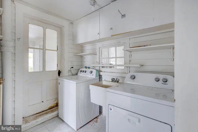 a utility room with cabinets washer and dryer