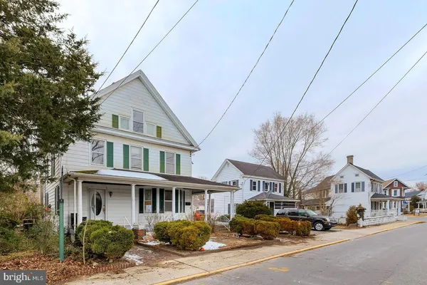 a front view of a house with cars parked on road