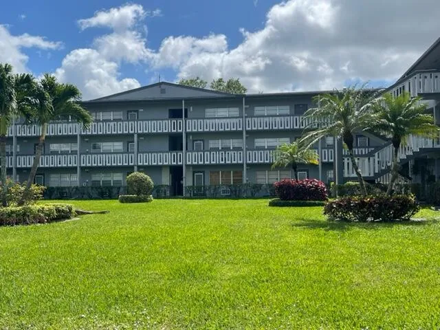a view of a house with a yard and sitting area