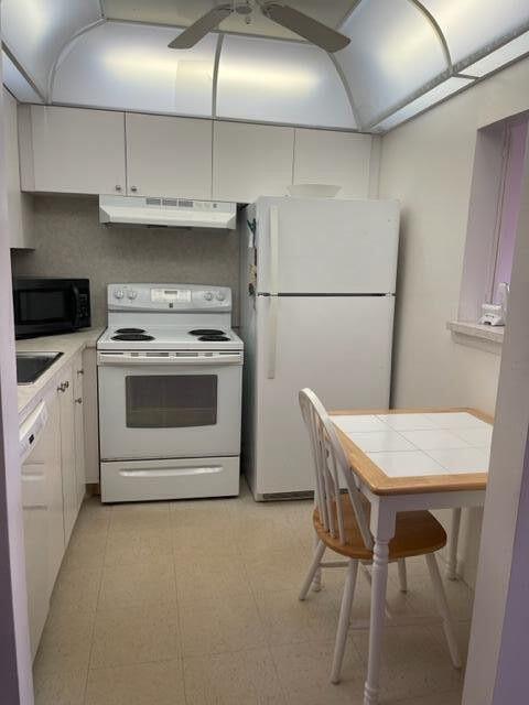 152 Suffolk F Boca Raton, FL 33434 - Photo 3 of 26 a kitchen with a stove a refrigerator and a table