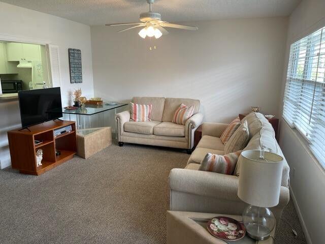 152 Suffolk F Boca Raton, FL 33434 - Photo 6 of 26 a living room with furniture a flat screen tv and kitchen view