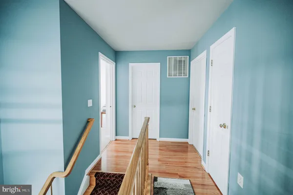 a view of a hallway with wooden floor and stairs