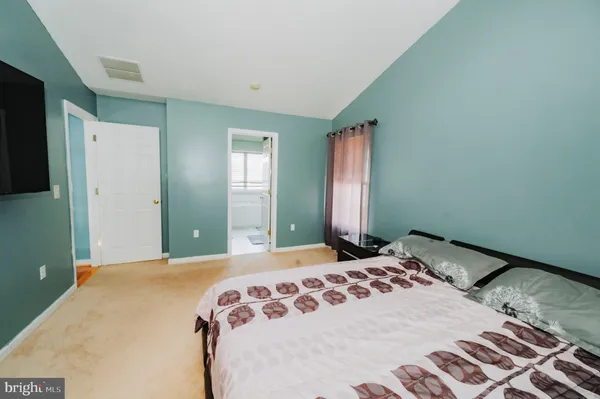a bedroom with a bed and a large mirror
