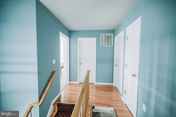 a view of a hallway with furniture and wooden floor