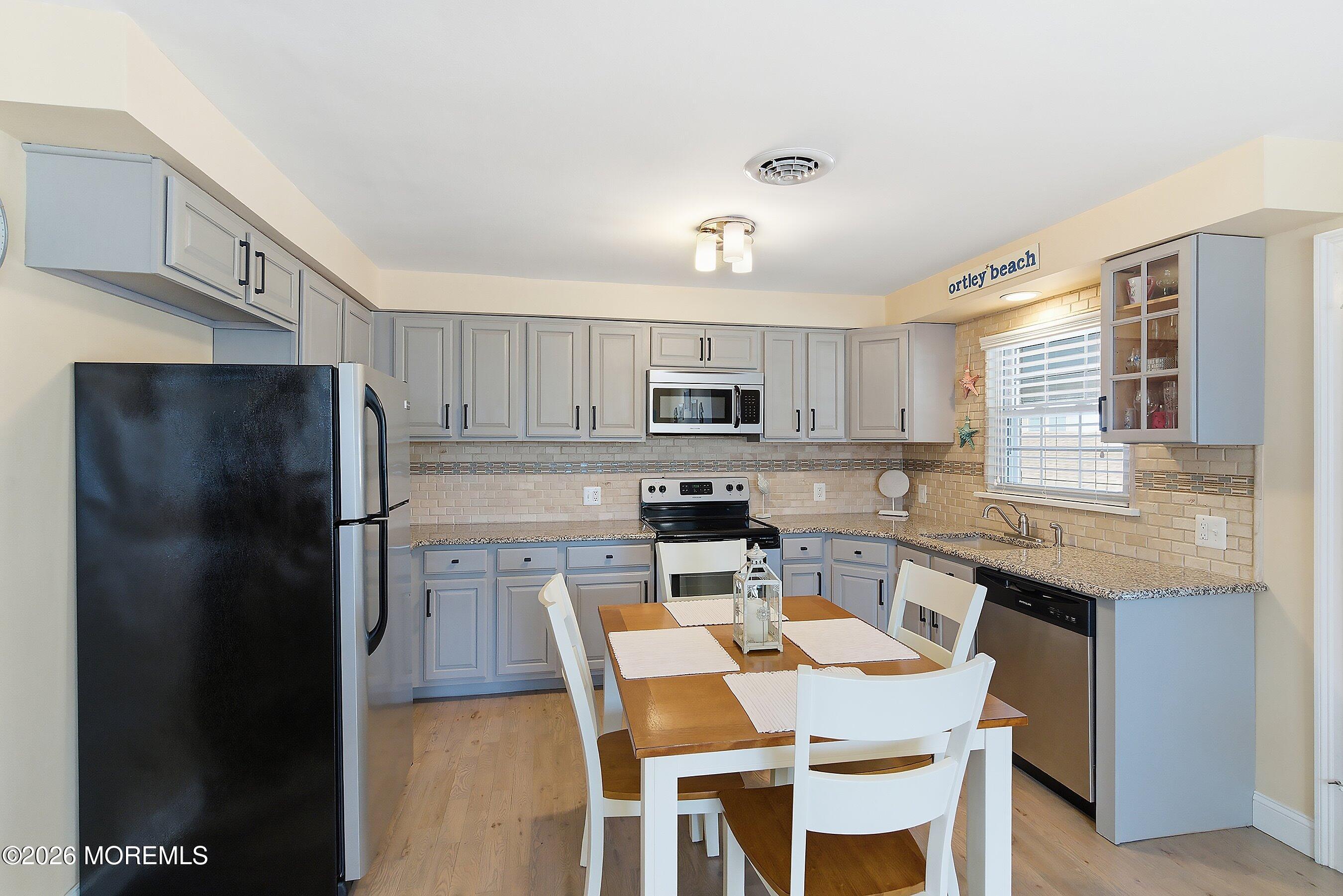 2060 Highway 35, Unit 3 Seaside Heights, NJ 08751 - Photo 8 of 17 a kitchen with stainless steel appliances granite countertop a refrigerator a stove a sink dishwasher a dining table and chairs