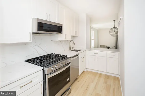 a kitchen with white cabinets stainless steel appliances and sink