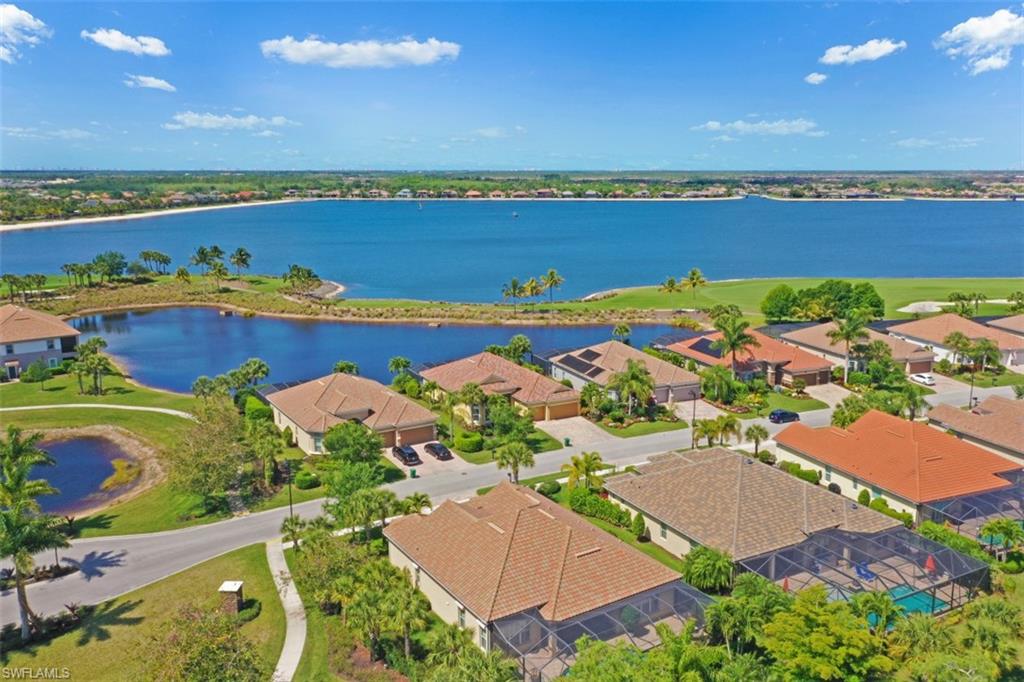an aerial view of ocean and residential houses with outdoor space