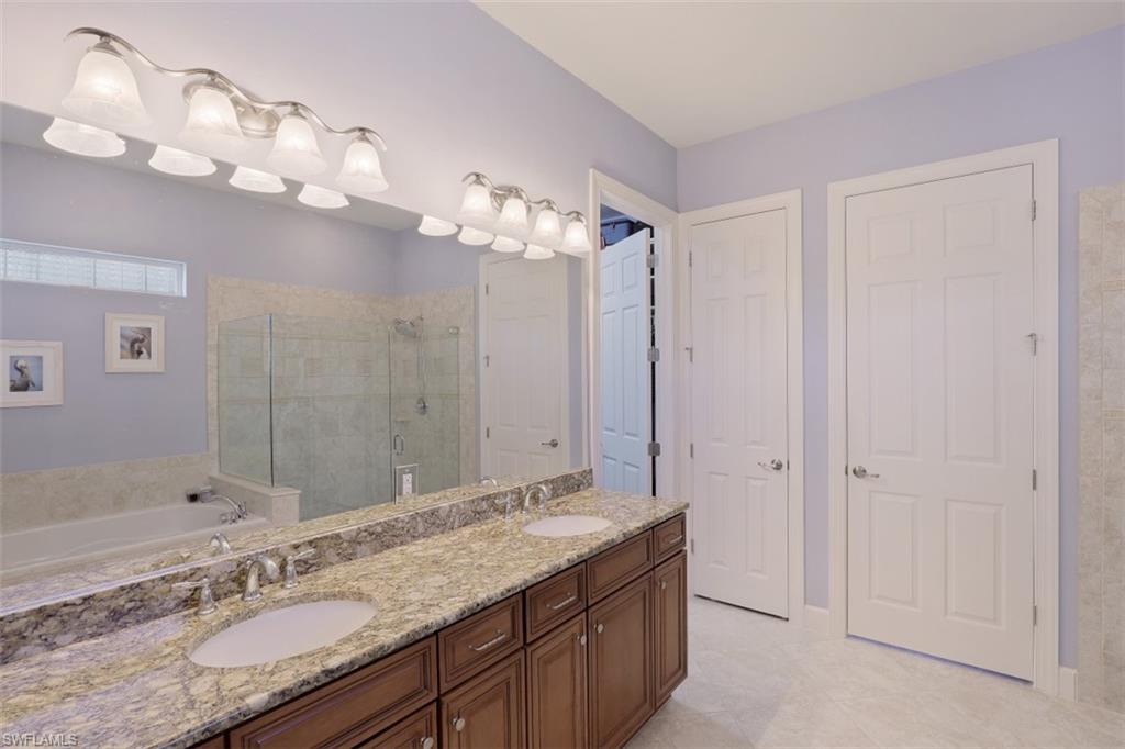 8962 Quarry Drive Naples, FL 34120 - Photo 12 of 35 a bathroom with a granite countertop double vanity sink and a mirror