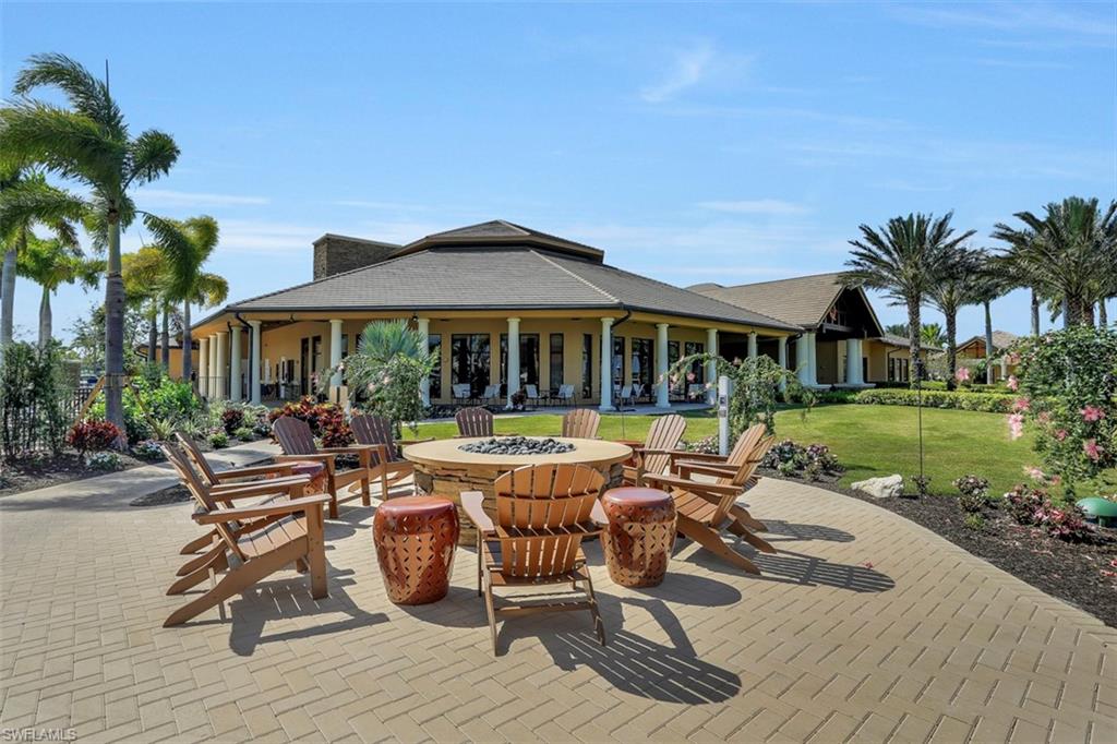 8962 Quarry Drive Naples, FL 34120 - Photo 33 of 35 a patio with a table and chairs under an umbrella