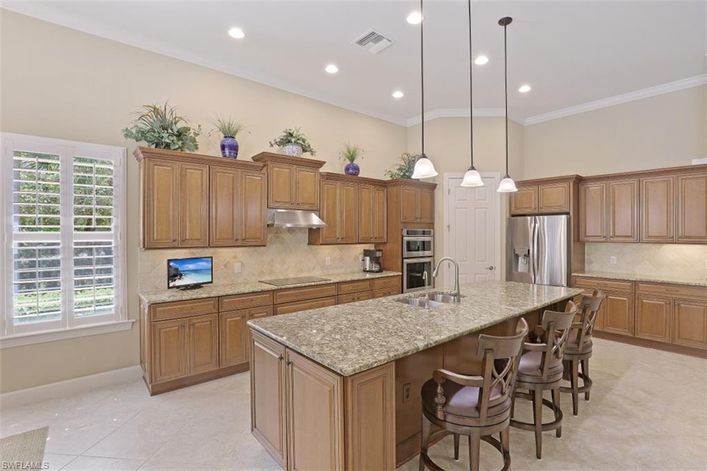8962 Quarry Drive Naples, FL 34120 - Photo 6 of 35 a kitchen with granite countertop a table and chairs in it