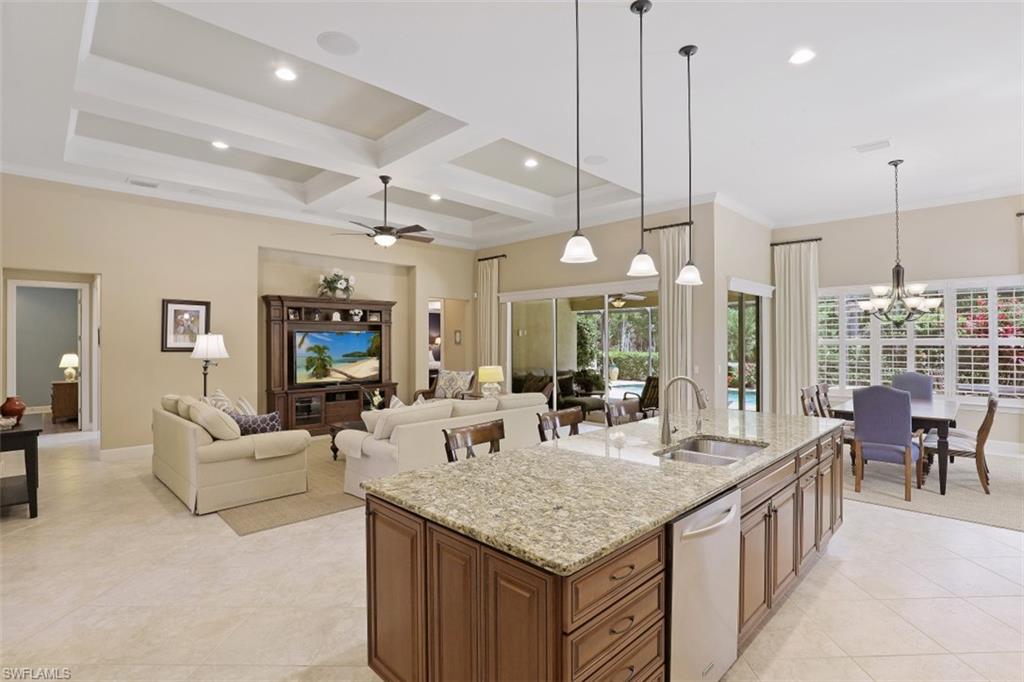 8962 Quarry Drive Naples, FL 34120 - Photo 8 of 35 a living room with furniture a chandelier and a flat screen tv