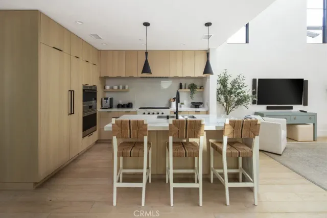 a kitchen with stainless steel appliances kitchen island granite countertop a table and chairs in it