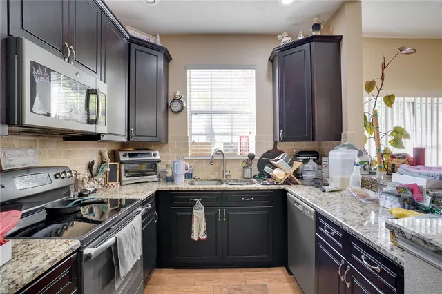 a kitchen with a sink stove top oven and cabinets