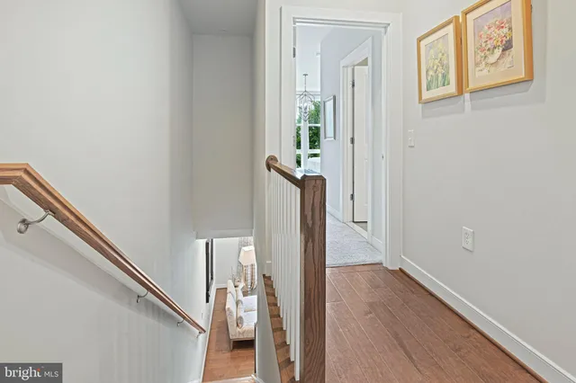 a view of a hallway with wooden floor and staircase