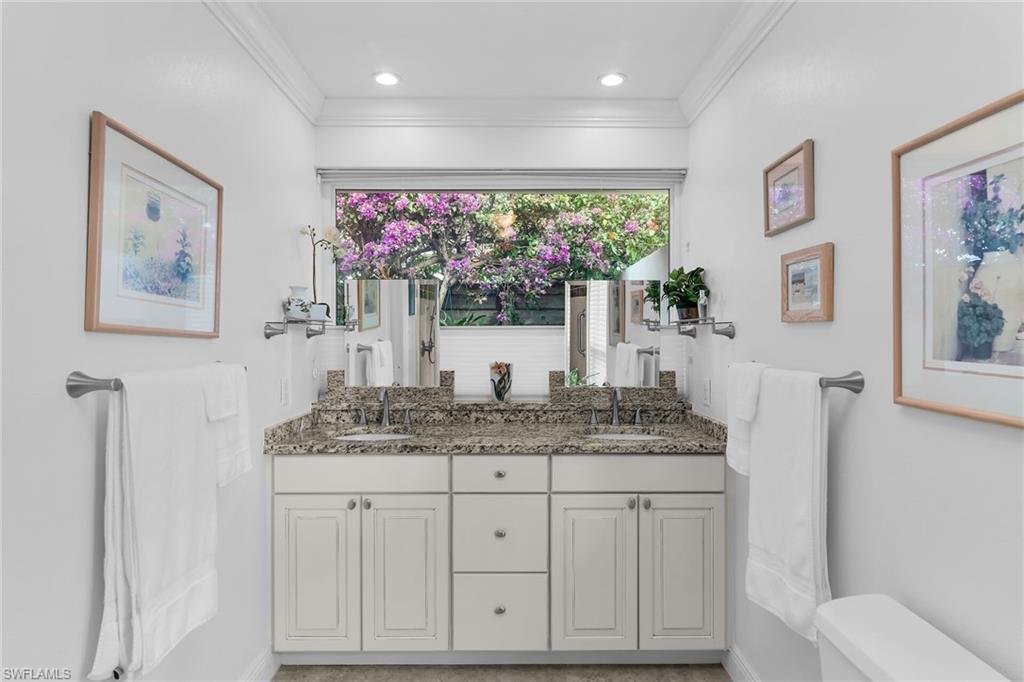 1916 Countess Court Naples, FL 34110 - Photo 19 of 43 a bathroom with a granite countertop sink a large mirror and painting on the wall