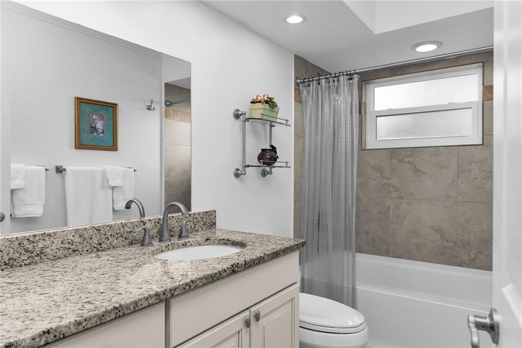 1916 Countess Court Naples, FL 34110 - Photo 26 of 43 a bathroom with a granite countertop sink toilet and shower