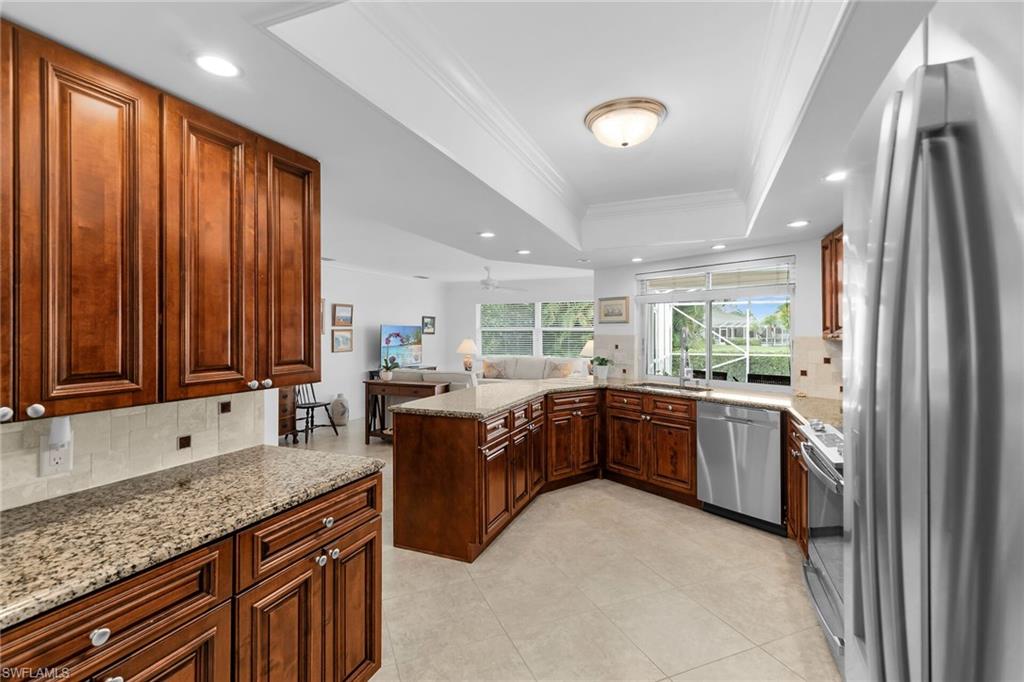 1916 Countess Court Naples, FL 34110 - Photo 31 of 43 a large kitchen with kitchen island granite countertop a sink stainless steel appliances and cabinets