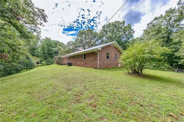 a view of a house with a yard and deck