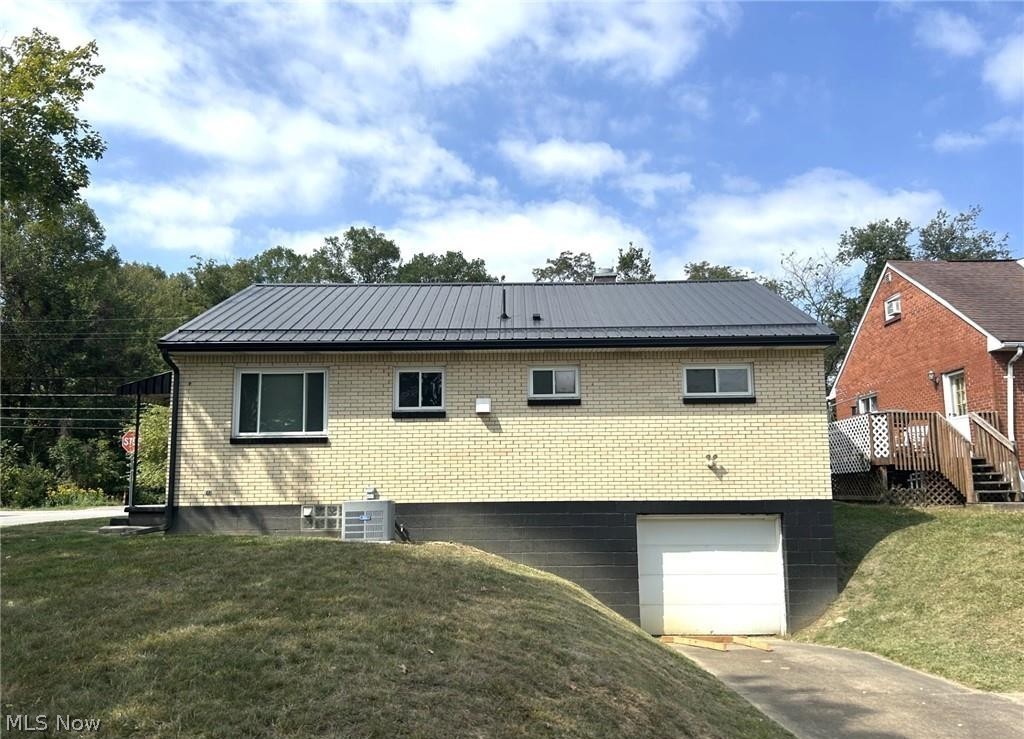424 Lee Road Follansbee, WV 26037 - Photo 12 of 12 Back view of home featuring brick siding, a garage, and a yard