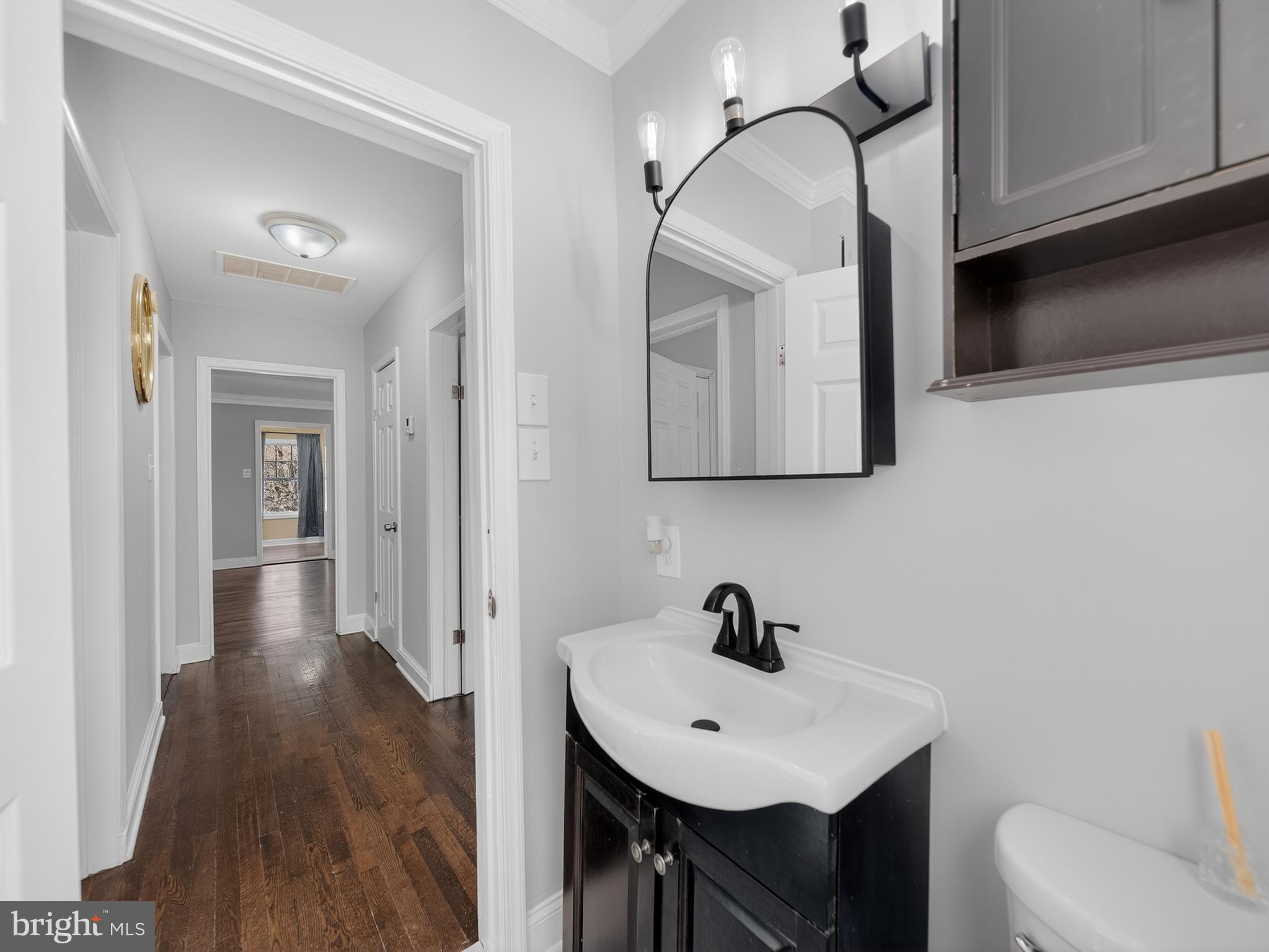 1815 Bonifant Road Silver Spring, MD 20906 - Photo 12 of 49 a bathroom with a toilet a sink and mirror