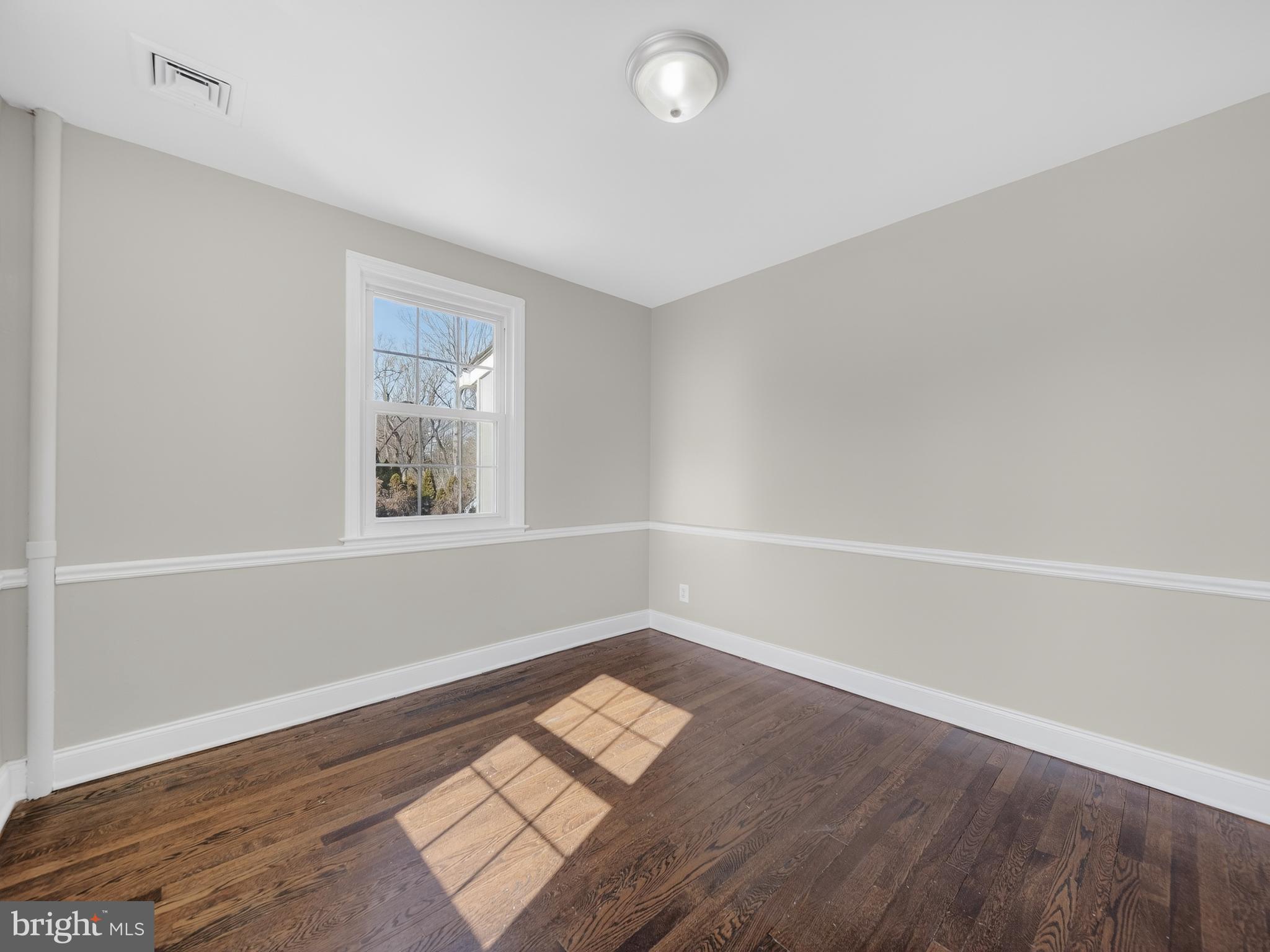 1815 Bonifant Road Silver Spring, MD 20906 - Photo 14 of 49 an empty room with wooden floor and windows