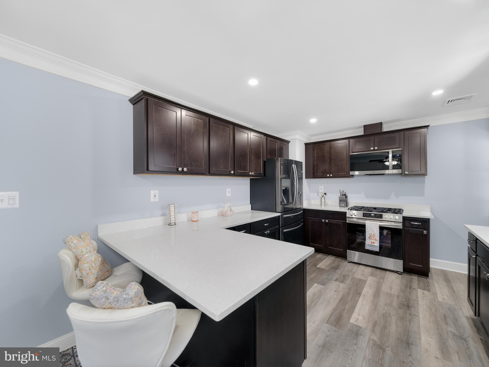 1815 Bonifant Road Silver Spring, MD 20906 - Photo 21 of 49 a kitchen with stainless steel appliances a stove a sink a microwave and cabinets