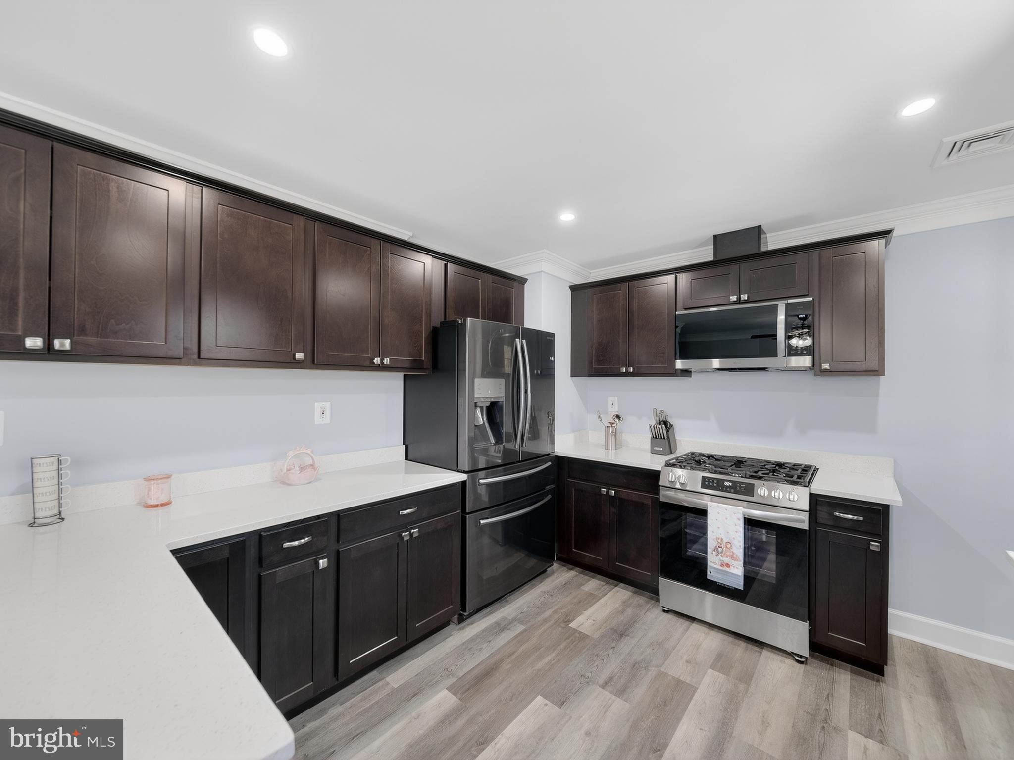 1815 Bonifant Road Silver Spring, MD 20906 - Photo 23 of 49 a kitchen with stainless steel appliances a sink a stove a refrigerator cabinets and a microwave