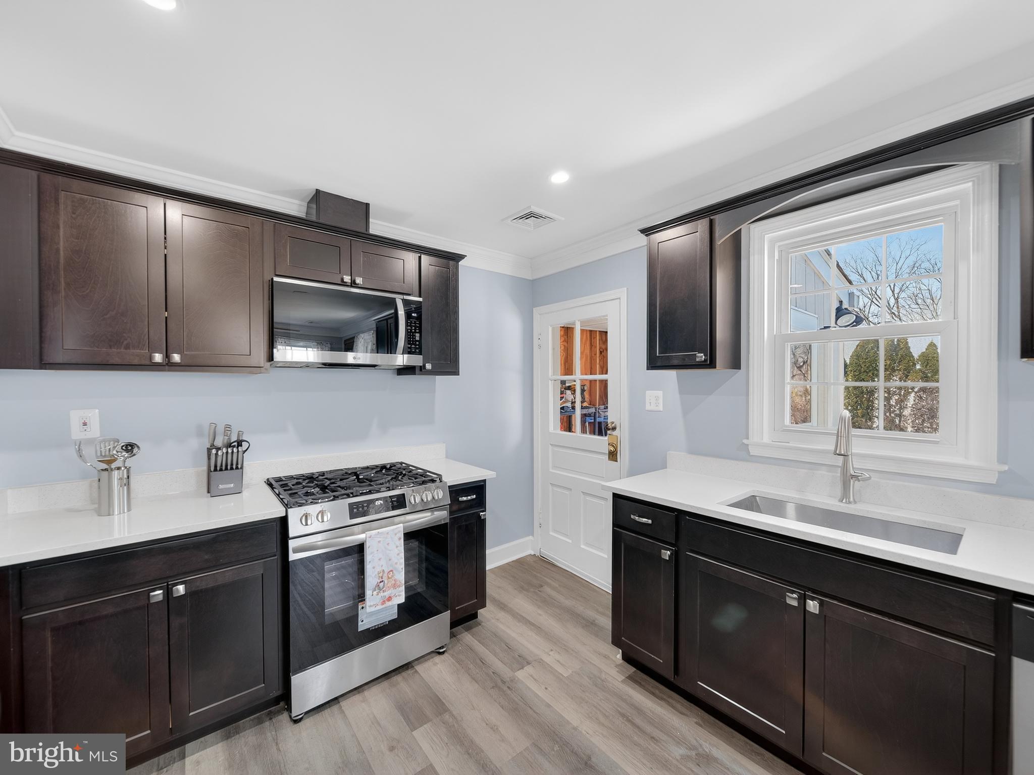 1815 Bonifant Road Silver Spring, MD 20906 - Photo 24 of 49 a kitchen with stainless steel appliances a sink cabinets and a stove top oven