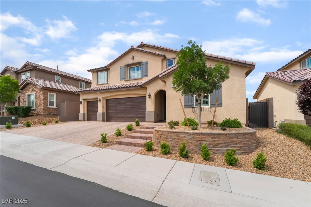 2575 Hazelburn Drive Henderson, NV 89044 - Photo 4 of 65 Mediterranean / spanish-style house with stucco siding, driveway, an attached garage, and a tile roof