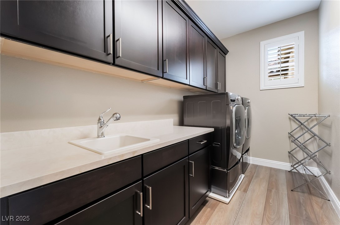 2575 Hazelburn Drive Henderson, NV 89044 - Photo 40 of 65 Washroom featuring washing machine and clothes dryer, cabinet space, and light wood-style floors