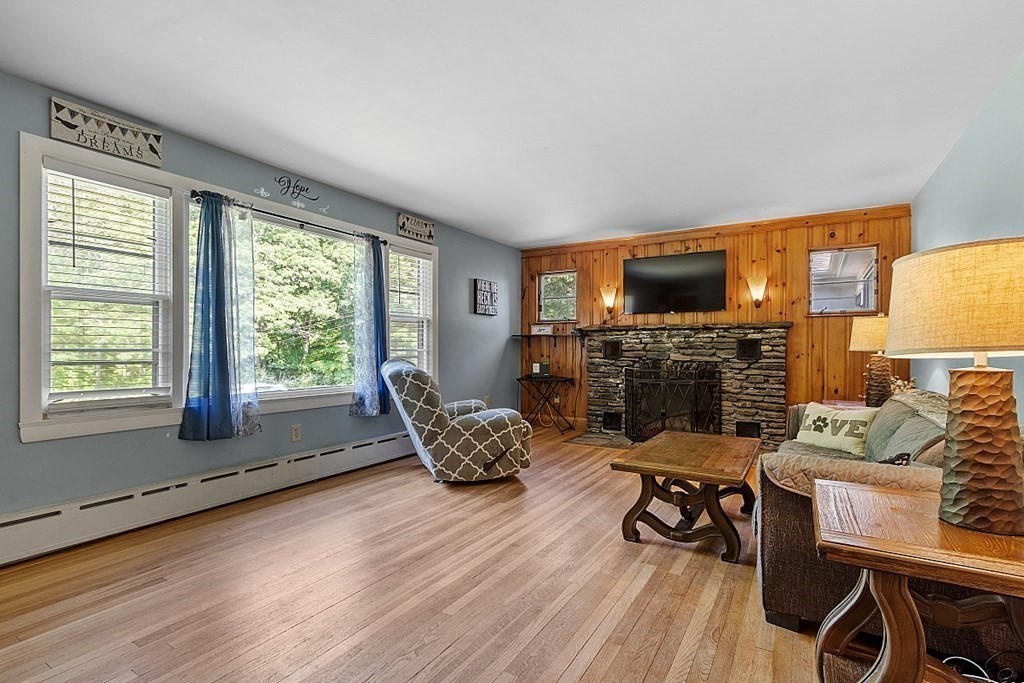 85 Blood Road Charlton, MA 01507 - Photo 18 of 30 a living room with furniture a fireplace and a flat screen tv