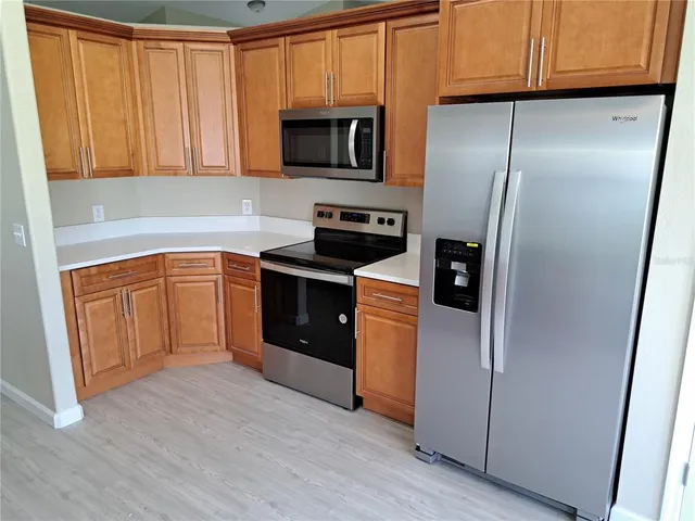 a kitchen with stainless steel appliances granite countertop a refrigerator a sink a stove and oven