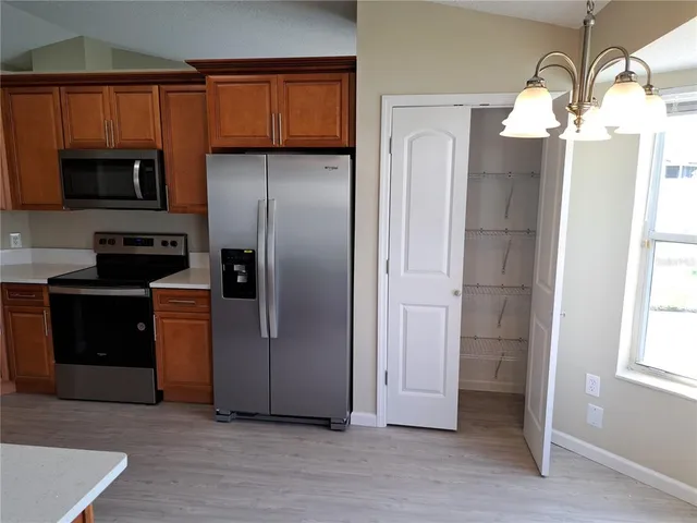 a kitchen with stainless steel appliances granite countertop a refrigerator and a stove top oven