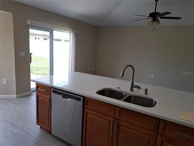 a kitchen with a sink and wooden floor