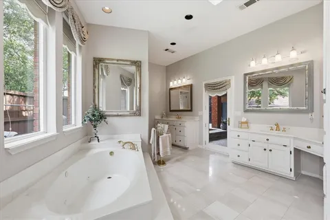 a bathroom with a tub sink and mirror