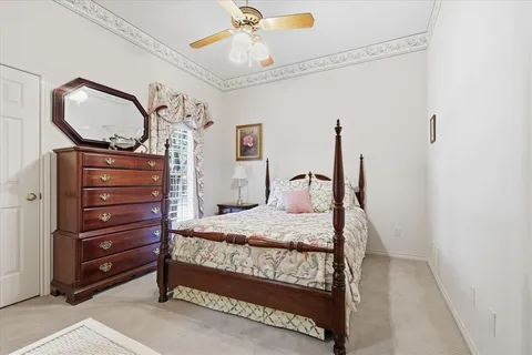 a bedroom with a bed window and dresser
