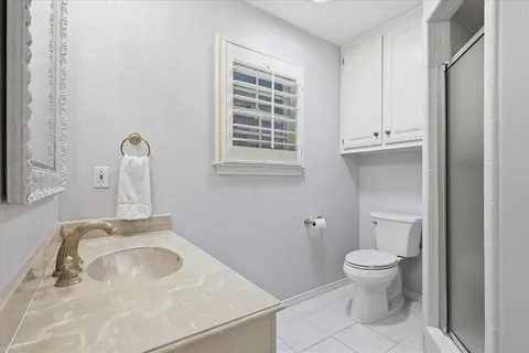a bathroom with a sink toilet and window
