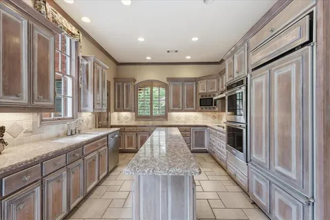 a kitchen with stainless steel appliances granite countertop a refrigerator and a sink