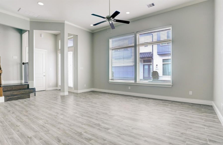 8907 Spring Knoll Forest Drive Houston, TX 77080 - Photo 10 of 21 This open living area exudes a clean and contemporary feel, with light gray flooring that enhances the spaciousness of the room. Large windows allow ample natural light to flow in, brightening the neutral-toned walls and creating a welcoming atmosphere.