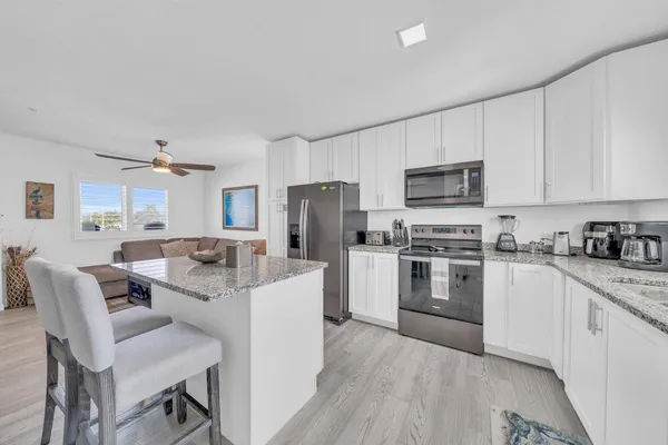 a living room with a sink and a wooden floor