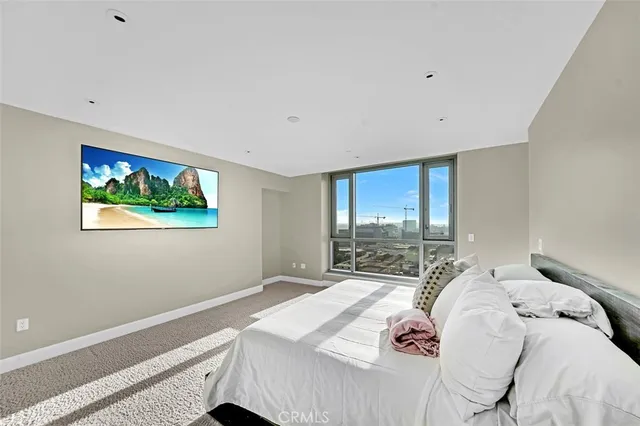 a bedroom with a bed and a large window