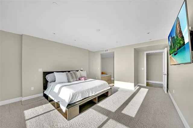 a bedroom with a bed and a flat screen tv