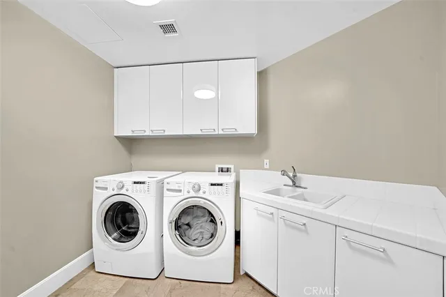 a utility room with sink dryer and washer