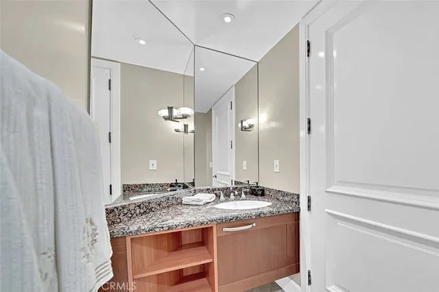 a bathroom with a granite countertop sink and a mirror